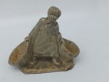 figurine représentant une femme assise dans un bateau avec un chien