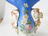 a blue vase with flowers on it on a white surface