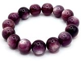 a close up of a bracelet with purple beads on a white background