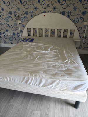 a white bed in a room with a blue and white wallpaper