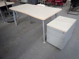 a desk with a file cabinet in the middle of a room