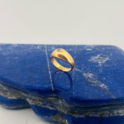 a close up of a gold ring on top of a blue stone