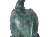 statue of a pelican sitting on a rock on a white background