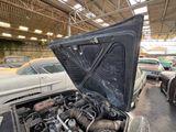 an old car with its hood open in a garage