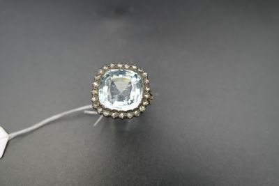 une bague sertie d'une aigue-marine et de diamants sur un fond noir