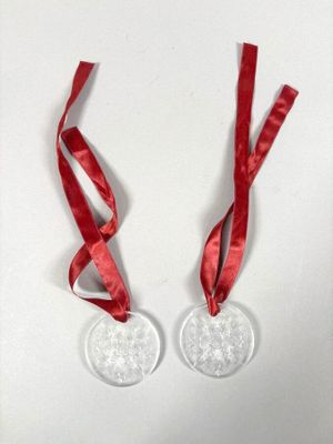 paire de décorations de Noël avec un ruban rouge et des flocons de neige sur fond blanc
