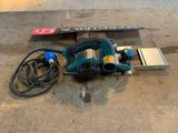a picture of a corded sander on the ground next to a sign