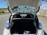 a white car with its trunk open on the street