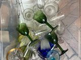 bottles and glasses in a clear box on a wooden floor