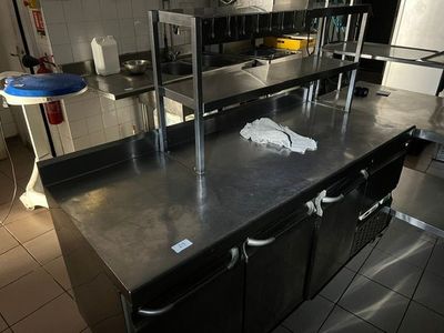une grande cuisine avec des plans de travail et des appareils électroménagers en inox