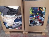 two cardboard boxes with clothes in them sitting on a pallet