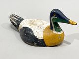 a wooden duck that is sitting on a white surface