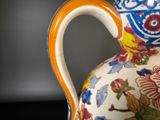 a colorful vase with a handle on a table