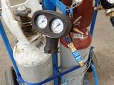 a blue cart with gas bottles and gauges on it