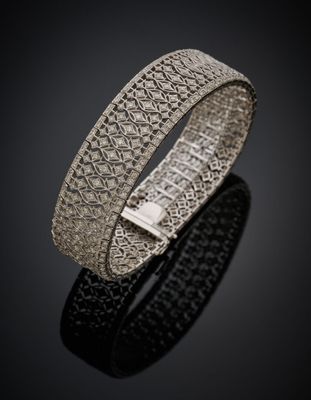 gros plan d'un bracelet en argent sur une surface noire