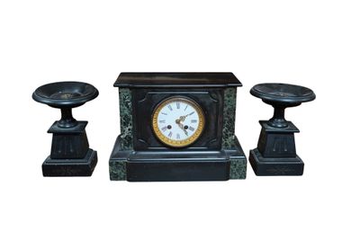 une horloge noire et deux bougies sur fond blanc