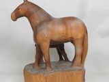 statue représentant un cheval et un poulain debout sur un bloc de bois