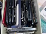 a lot of cell phones in a container on the table
