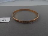 a gold bracelet on a table next to a price tag