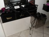 a desk with a mirror, a camera, a hair dryer, and a hair dryer on it