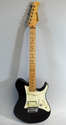 a black electric guitar sitting on top of a white wall