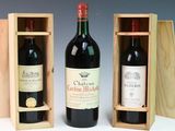 two bottles of red wine in wooden cases on a table