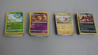 Quatre types différents de cartes Pokémon sont alignées sur une table
