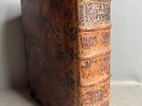 an old book sitting on top of a table next to a wall