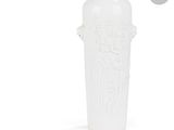 un vase blanc orné d'un motif sur fond blanc