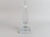 un bougeoir en verre transparent posé sur une surface blanche