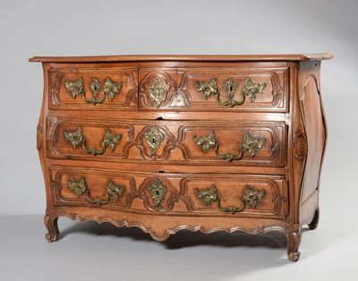une vieille commode en bois ornée de sculptures raffinées et dotée de poignées en laiton