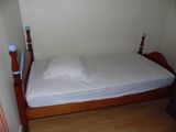 a bed with a white sheet on it in the corner of a room