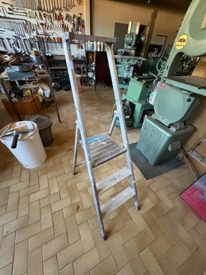 une photo d'une pièce avec une échelle et de nombreux outils