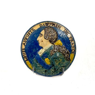 un bouton bleu et jaune sur lequel figure l'image d'une femme