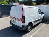 a white van parked in a parking lot with a surfboard on the roof