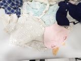 a pile of clothes on a table with a teddy bear
