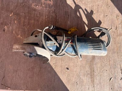 a picture of a drill on the ground next to a piece of wood