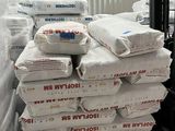 many bags of cement sitting on a pallet in a warehouse
