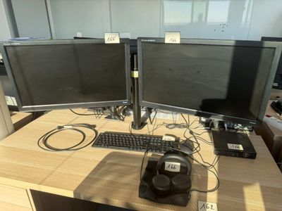 two computer monitors sitting on top of a wooden desk