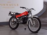 a red motorcycle parked in front of the pinnacle collection sign