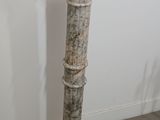 a tall white pedestal with a flower on top of it