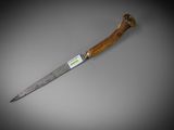 a knife with a wooden handle on a gray surface