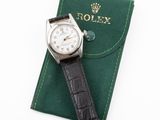 an image of a rolex watch sitting on top of a green case