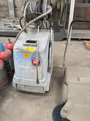 a machine that is sitting on the ground next to some barrels