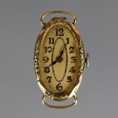 a gold clock hanging from the side of a wall
