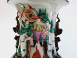 a vase with a painting on it sitting on a table