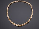 un collier en or avec un motif de corde torsadée sur fond noir