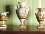 trois vases posés sur une table, avec un mur vert en arrière-plan