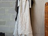 a wedding dress hanging on a clothes rack in a room