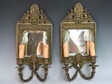 deux miroirs accrochés au mur, avec des bougies à l'intérieur